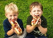 Kids eating hot dogs from hot dog machine